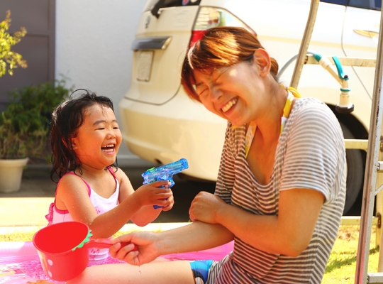ビニールプールで遊ぶ母と娘の写真